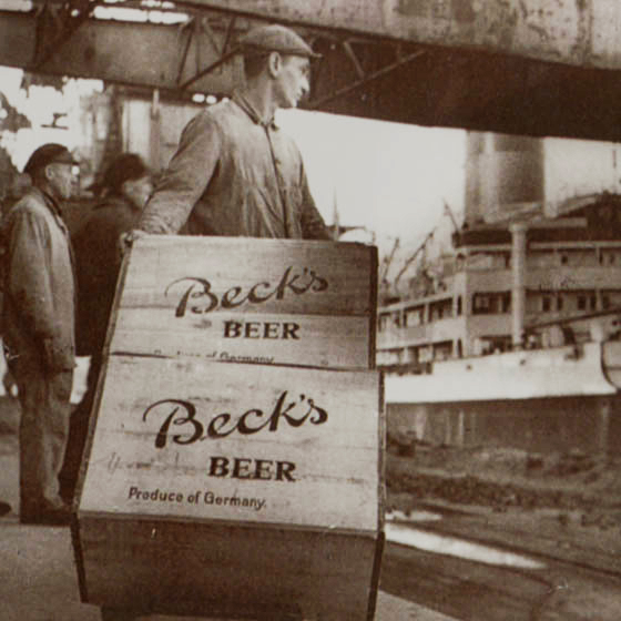 Ein Mann mit zwei Holzkisten mit der Aufschrifft 'BECK´S'